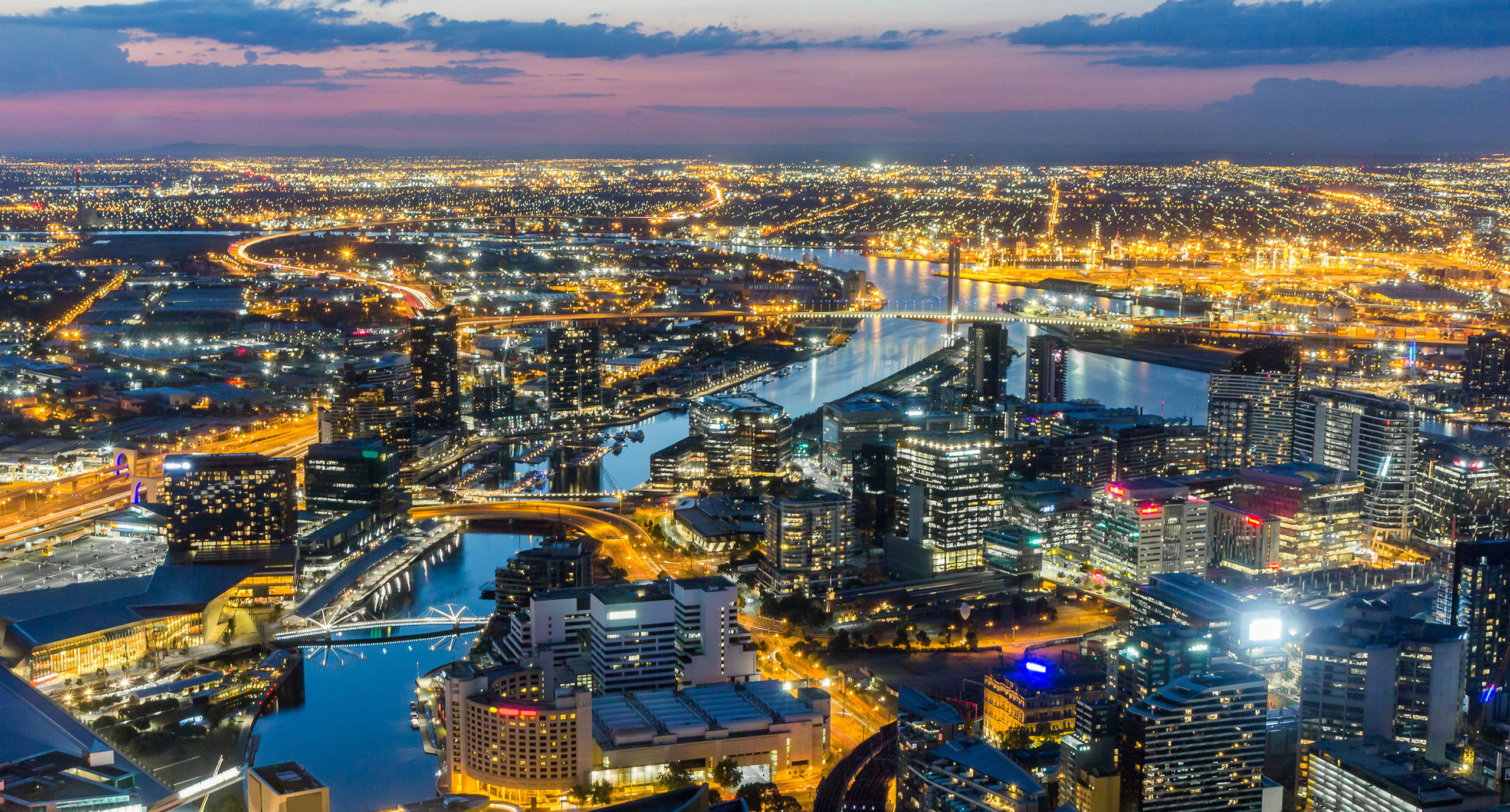 Melbourne City Aerial View Panorama Skyline Cityscape, Harbour, Seafarers Bridge, Bolte Bridge over Yarra River at Dusk Evening Sunset from Eureka Tower on South Bank, Victoria, Australia
